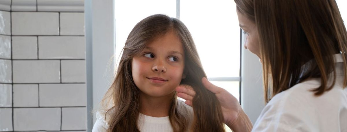 Parent or clinician examining a child’s hair and scalp for early signs of alopecia areata, helping recognize symptoms and determine when to see a doctor.