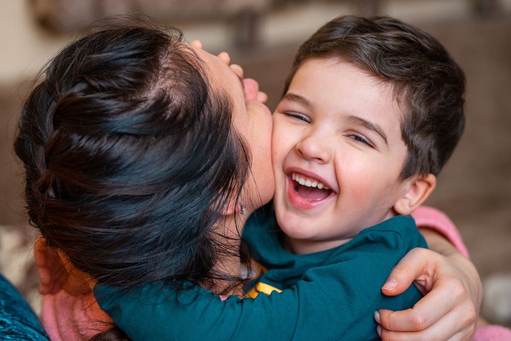 Close-up of a joyful mother and child embracing indoors, filled with warmth and happiness.